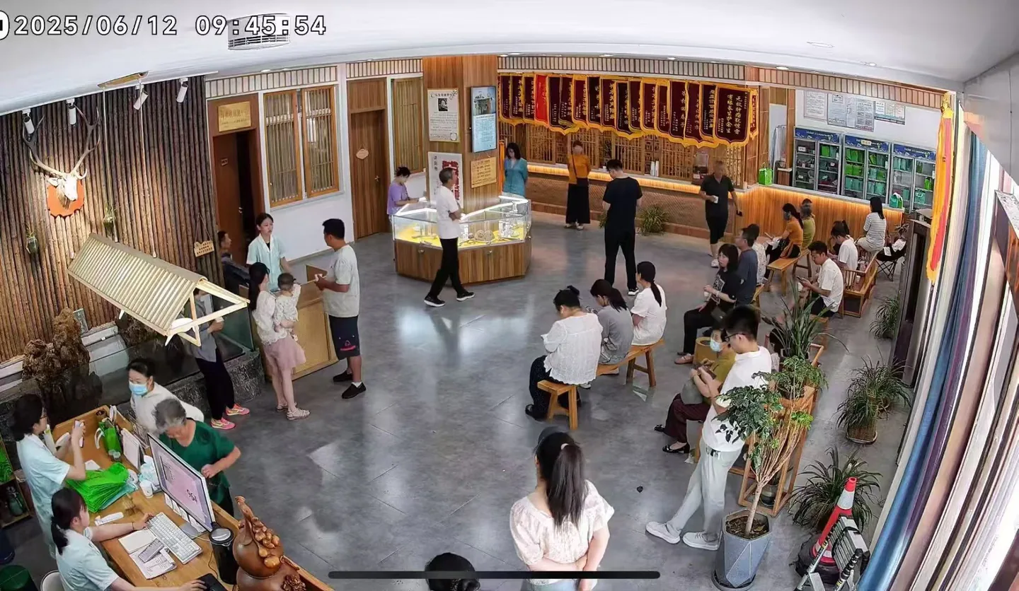 长生源门诊全景，来访者在木质座椅上候诊，医护人员在诊所内交流